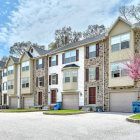 A row of townhomes in a beautiful community with trees blossoming.
